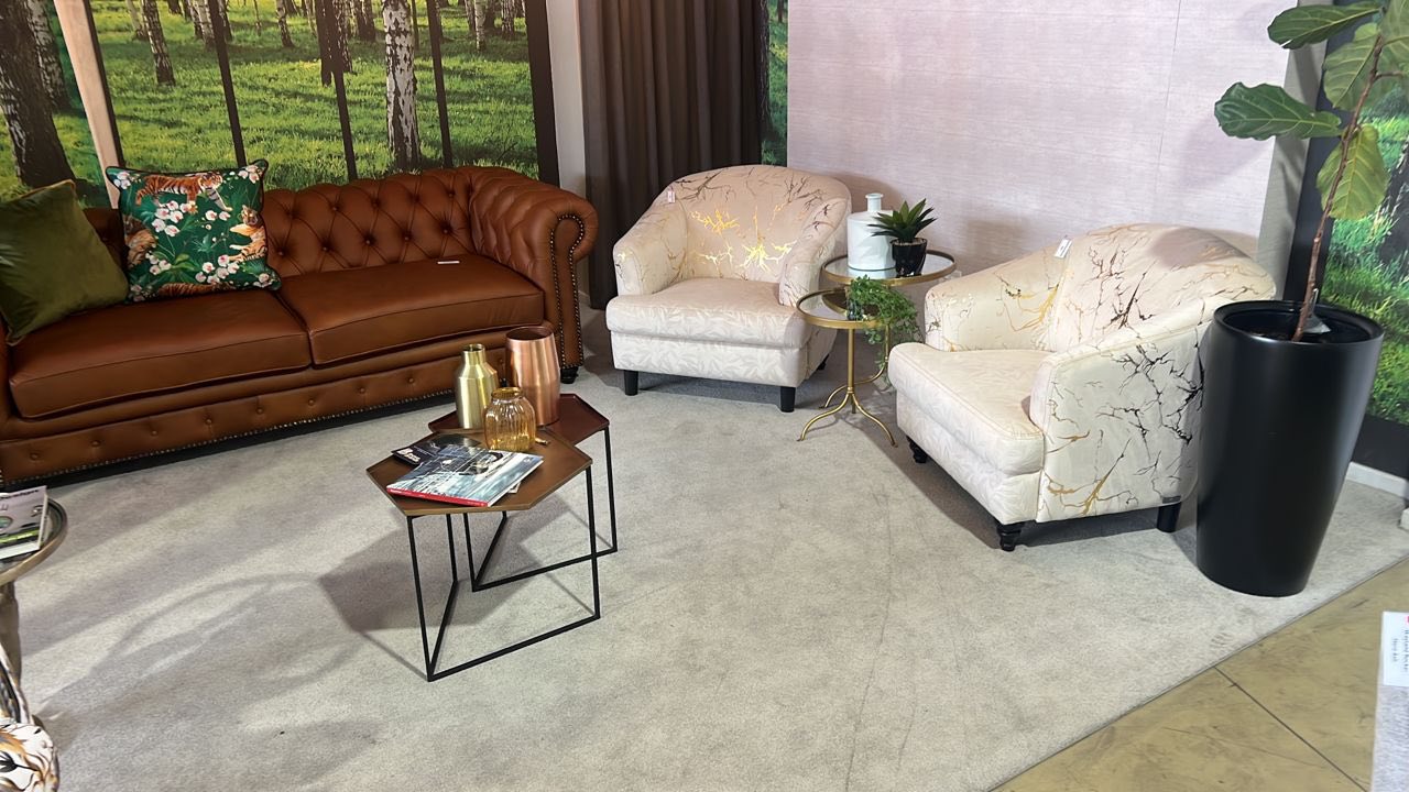 Showroom display with leather Chesterfield sofa and decorative chairs
